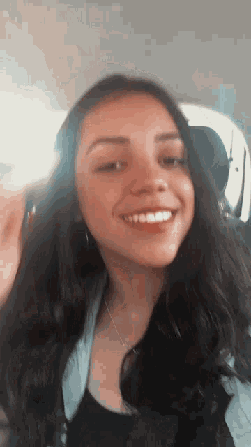 a young woman with long hair is smiling in a car