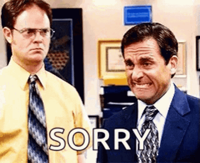 two men in suits and ties are standing next to each other and one of them is saying sorry