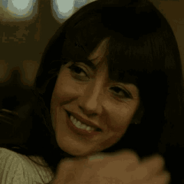 a close up of a woman 's face with a man 's hand covering her mouth .