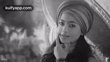a woman wearing a turban is sitting in front of a mirror .
