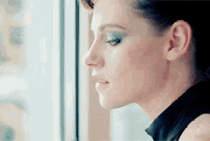 a close up of a woman 's face looking out the window