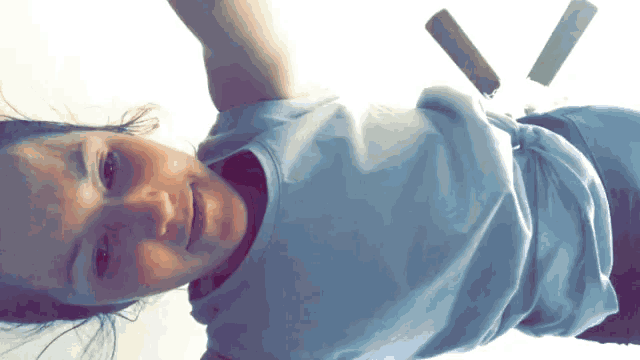 a woman in a white shirt is laying on her back with her arms outstretched
