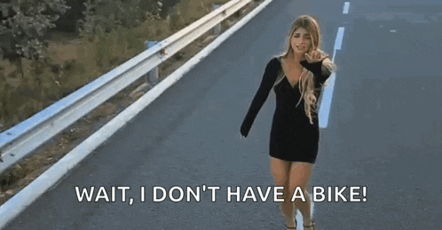 a woman in a black dress is walking down a road with the words wait , i don 't have a bike .