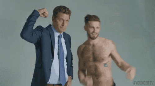 two men in suits and ties are flexing their muscles next to each other .