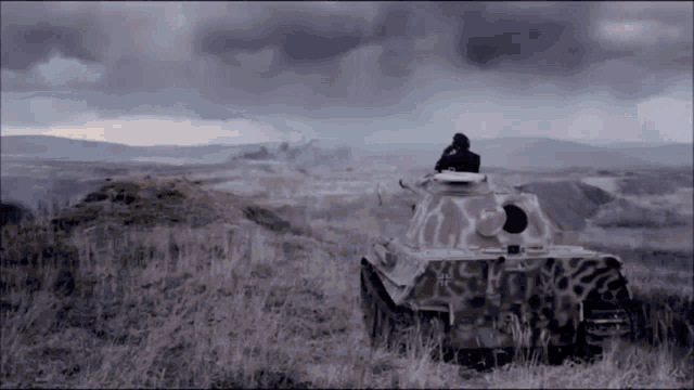 a man in a tank is looking out over a field