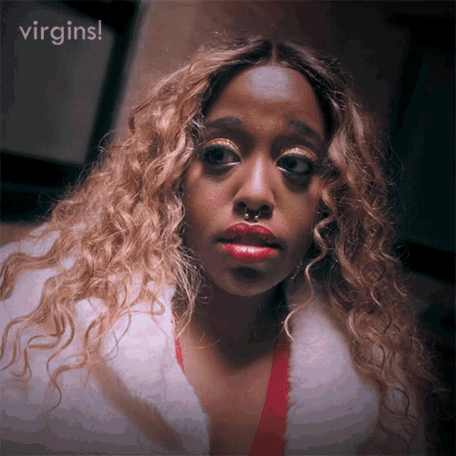 a close up of a woman 's face with the words virgins behind her