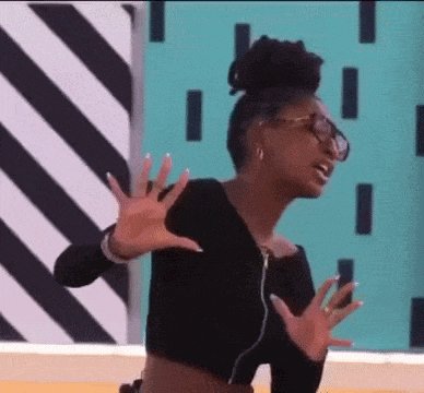 a woman wearing glasses and a black crop top is dancing