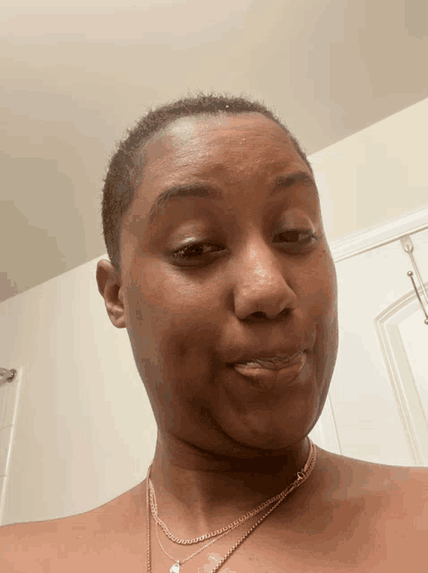 a woman without a shirt is wearing a necklace