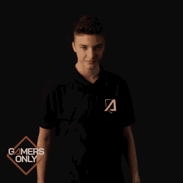 a young man in a black shirt stands in front of a gamers only logo