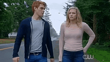 a man and a woman are walking down a street .