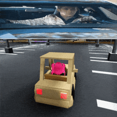 a man is driving a car in a parking lot with a girl in the back seat