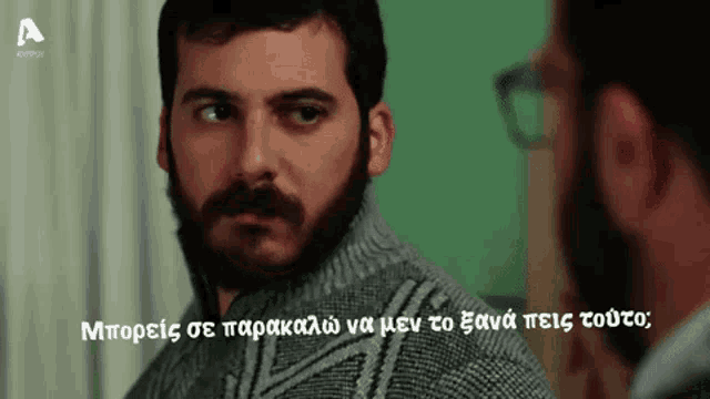 a man with a beard and mustache is talking to another man with glasses and the word a on the bottom right