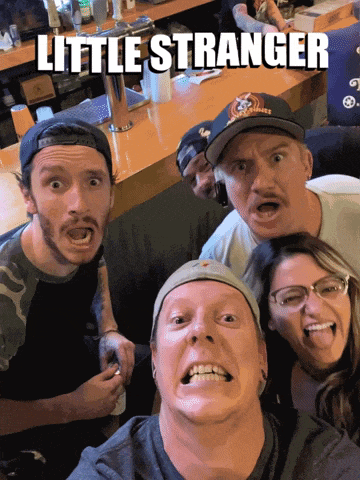 a group of people posing for a picture with the words little stranger above them