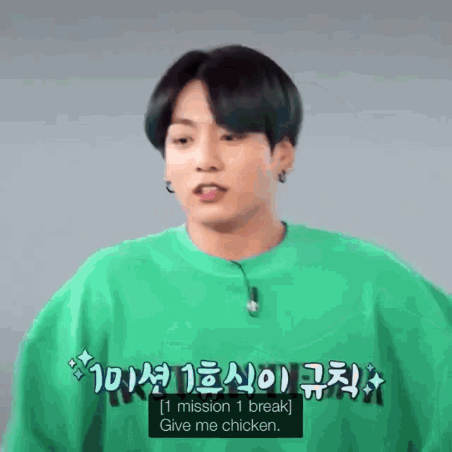 a young man wearing a green sweater is talking to someone in a foreign language .