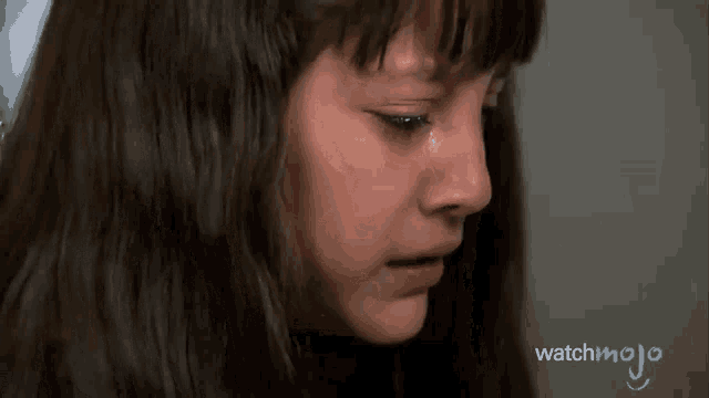 a close up of a girl 's face with a watchmojo logo on the bottom
