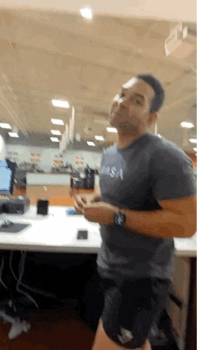 a man wearing a nasa shirt and shorts is running in an office