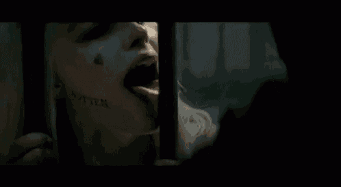a woman is licking a man 's face in a dark room .