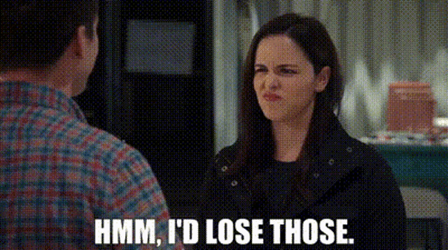 a man and a woman are talking to each other and the woman is making a face .