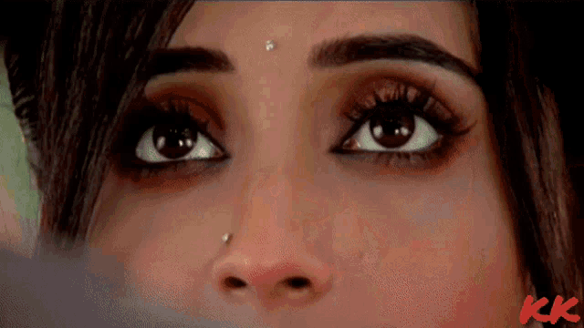a close up of a woman 's eyes with the letters kk visible