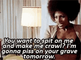 a woman with an afro is sitting in a room with a lamp and a lampshade while talking to someone .