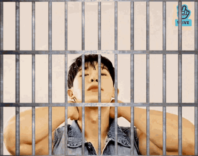 a man in a jail cell with a vlive logo on the bottom right