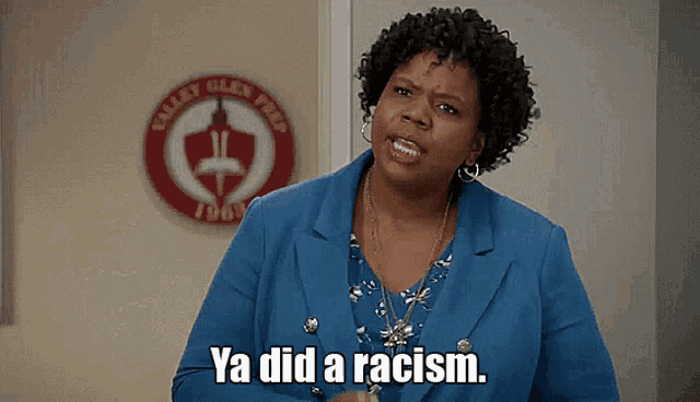 a woman in a blue jacket is saying ya did a racism ..