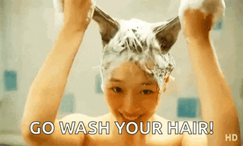 a woman is washing her hair in a bathtub with a cat 's ears on it .