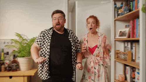 a man in a checkered shirt is standing next to a woman