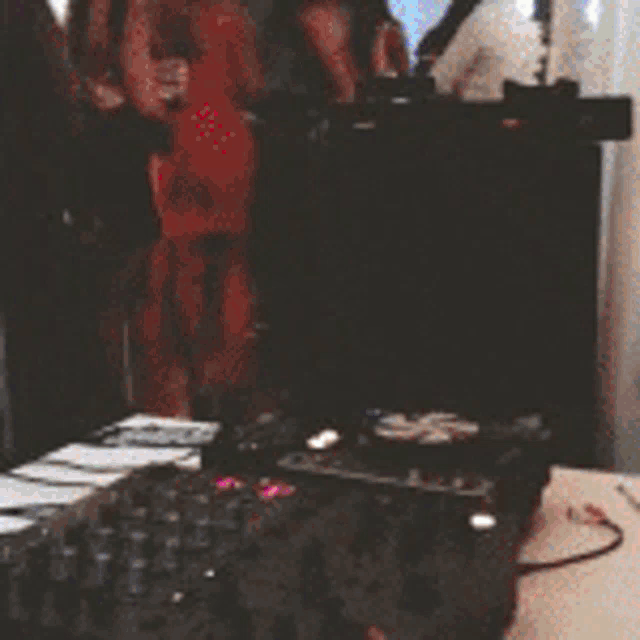 a woman in a pink dress is dancing with a man in a black suit at a party .