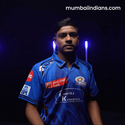 a man wearing a blue shirt that says " mumbai indians " on it