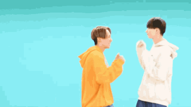 two people are standing next to each other with their arms outstretched