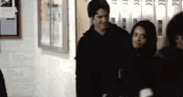 a man and a woman are standing in a hallway next to each other .