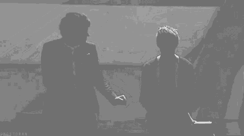 a couple of men are standing next to each other on a stage .