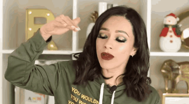 a woman wearing a green hoodie that says you wouldn 't you would