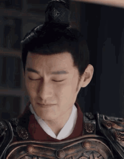 a close up of a man wearing armor and a top knot