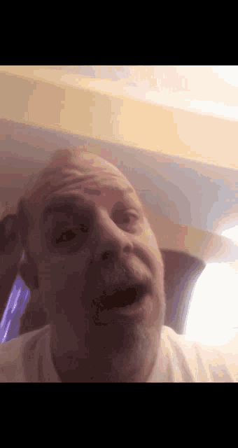 a man with a beard is making a funny face while wearing a white shirt