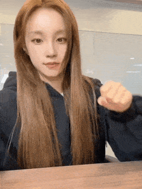 a woman with long hair is sitting at a table
