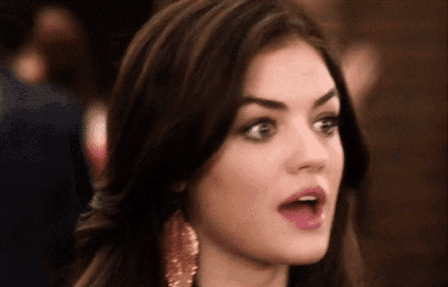a close up of a woman making a surprised face with her mouth open .