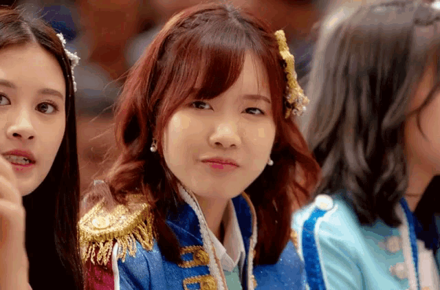 a girl with red hair is wearing a blue jacket that says ' nct ' on the front