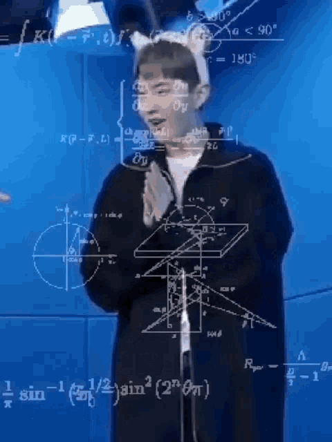 a man wearing a cat ear headband is standing in front of a blue wall with mathematical equations on it