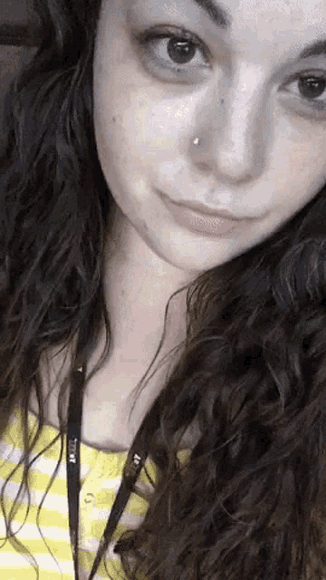 a close up of a woman 's face with a lanyard around her neck