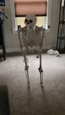 a skeleton is standing in a living room next to a window .