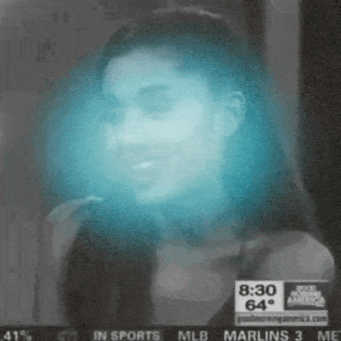 a close up of a woman 's face with a blue light behind her .