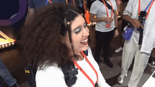 a woman wearing a lanyard that says ' a ' on it is smiling