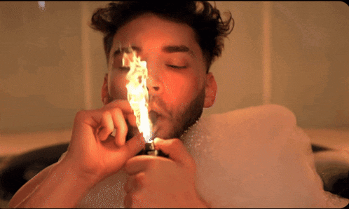 a man in a bathtub lighting a lighter