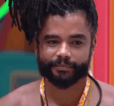 a shirtless man with dreadlocks and a beard wearing a necklace