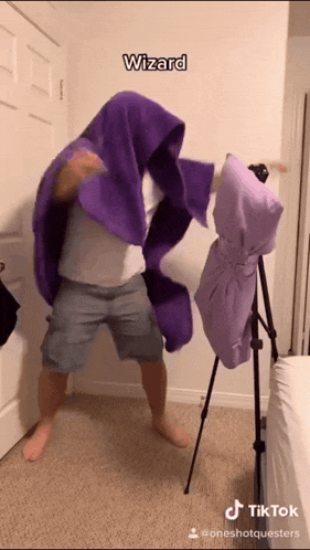 a man wearing a purple blanket with the word wizard on the bottom