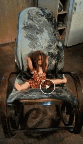 a doll is sitting on a rocking chair with a circle around her