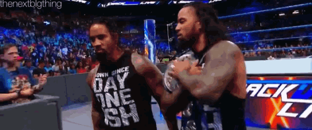two wrestlers are standing next to each other and one of them has a shirt that says day one ish