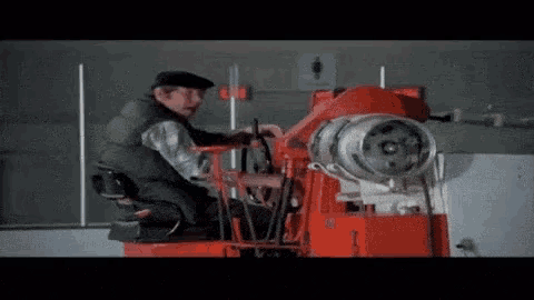 a man is sitting in the driver 's seat of a machine .